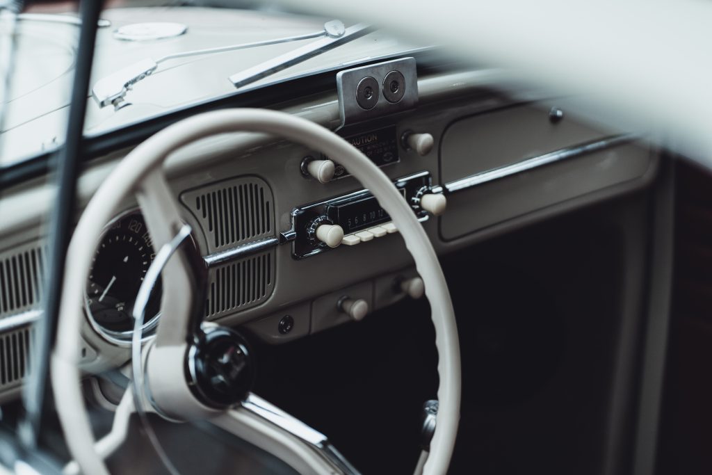 Interior of a vintage car. Steering wheel and dashboard. Black and silver