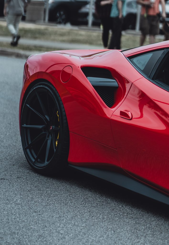 Close up of a red Ferrari with black wheels