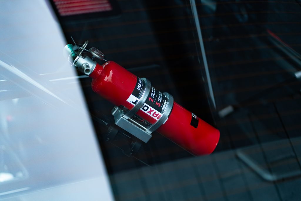 Closeup of a red fire extinguisher in a race car