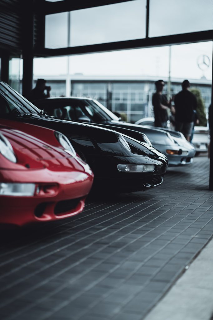 Selective focus on the front of red sport car in parking lot