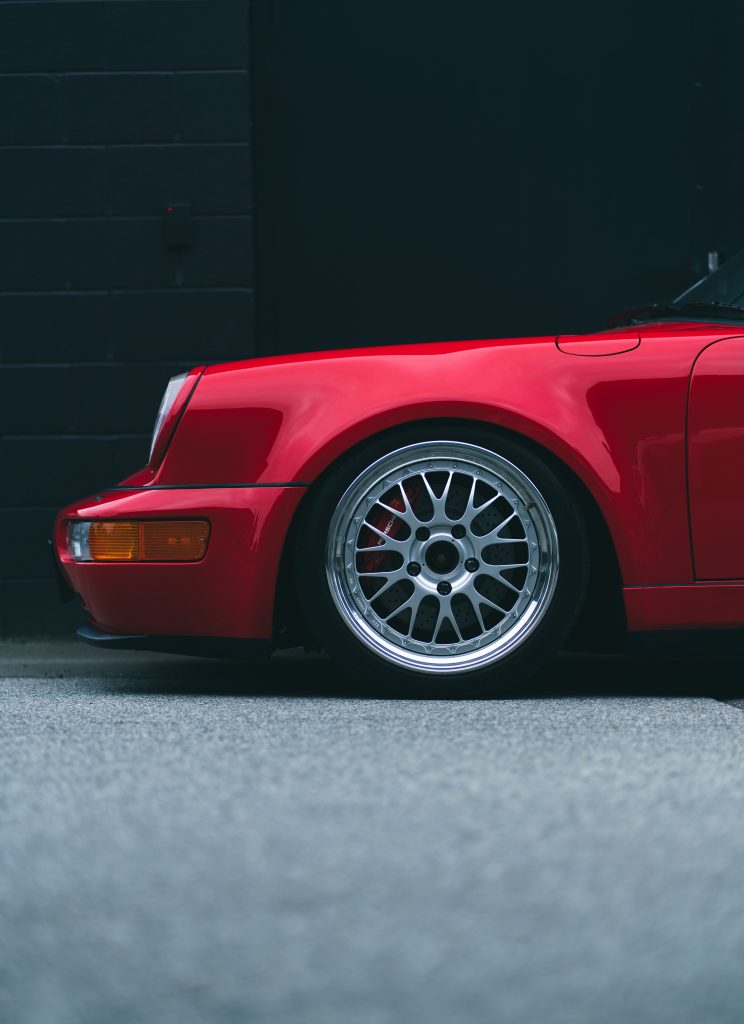 Front view of a red vintage sports car on the road. Close-up.