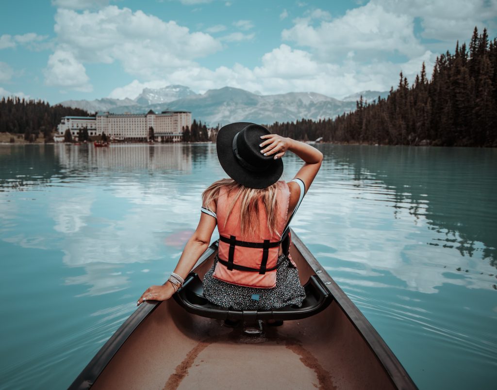 A back view of a woman in black hat sitting on the boat