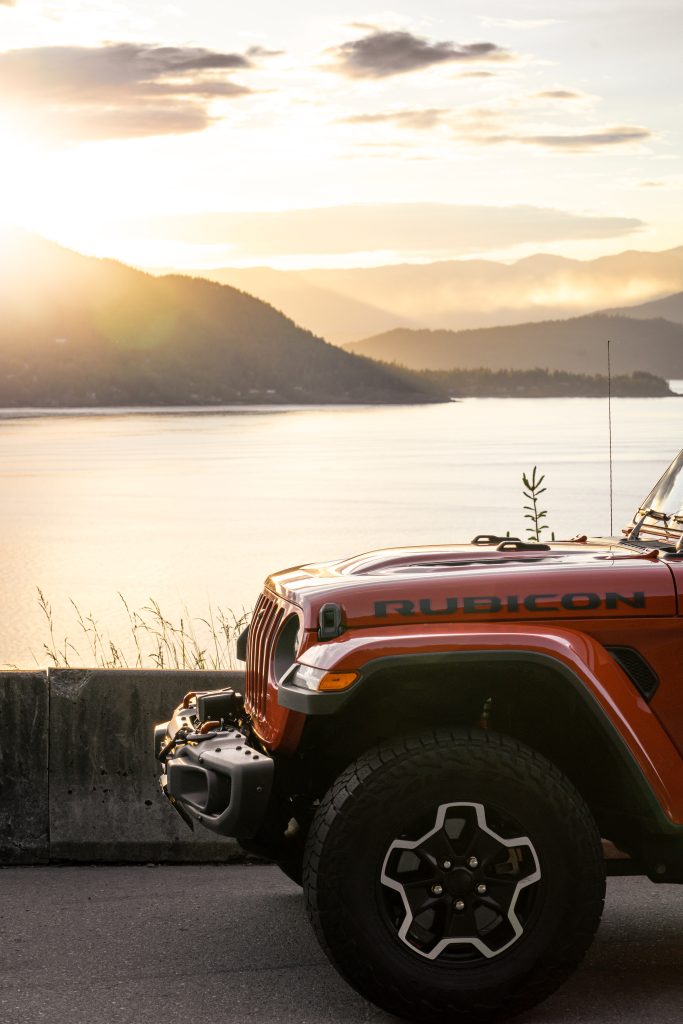 A jeep wrangler parked near a body of water