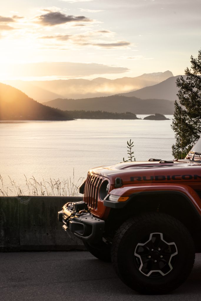 A jeep wrangler parked near a body of water