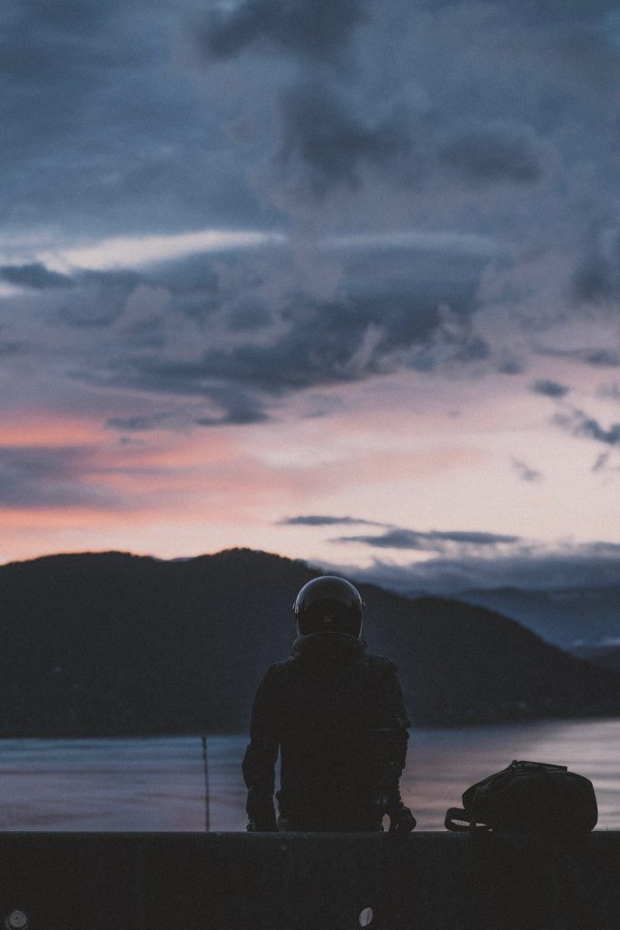 Person in helmet sitting at dusk