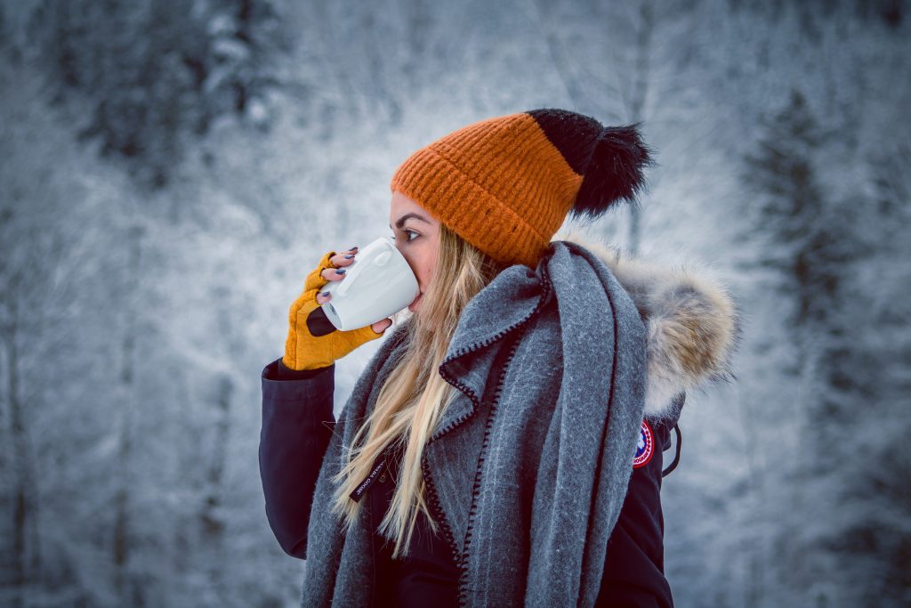 Woman holding white ceramic mug