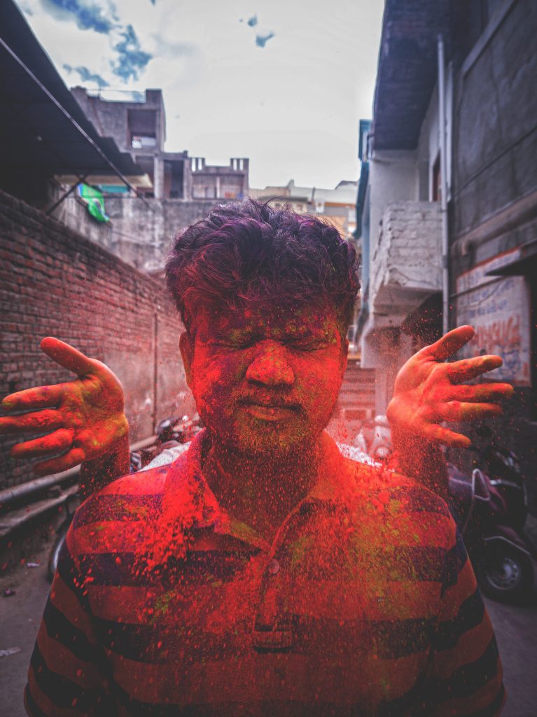 Vibrant Holi Festival: Captivating Image of a Man Covered in Red Powder Celebrating the Indian Festival