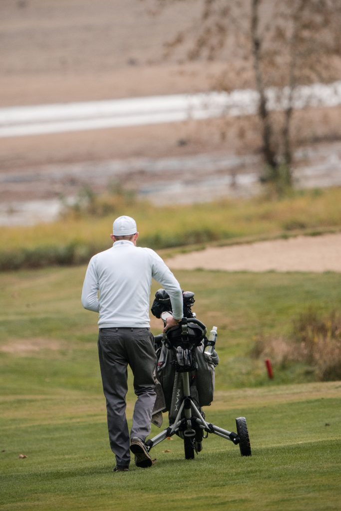 Golfer on a golf course in the early morning, back view